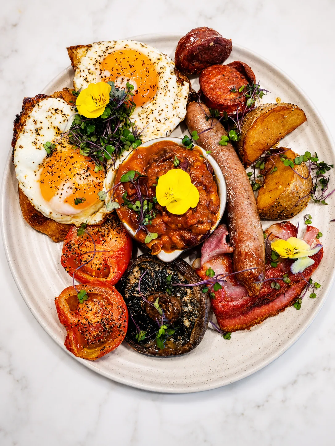 A Cafe Elia big breakfast with eggs, sausages, bacon, mushrooms and tomatoes